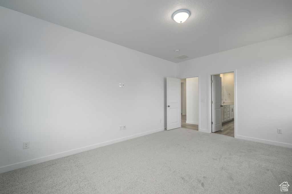 Unfurnished bedroom with baseboards, carpet floors, and ensuite bathroom