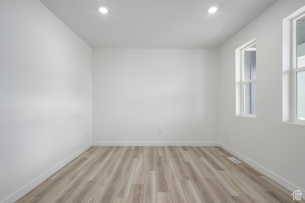 Spare room with light wood-type flooring, baseboards, and recessed lighting