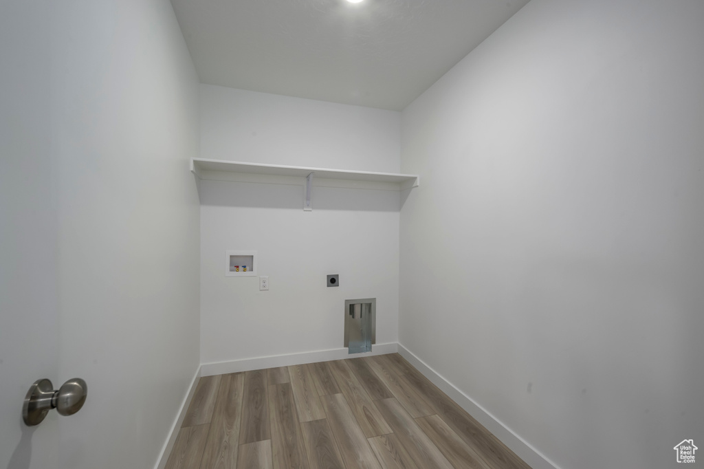 Washroom with hookup for a washing machine, wood finished floors, baseboards, and electric dryer hookup