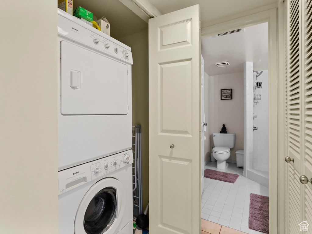 Laundry room with stacked washer / dryer and light tile patterned floors