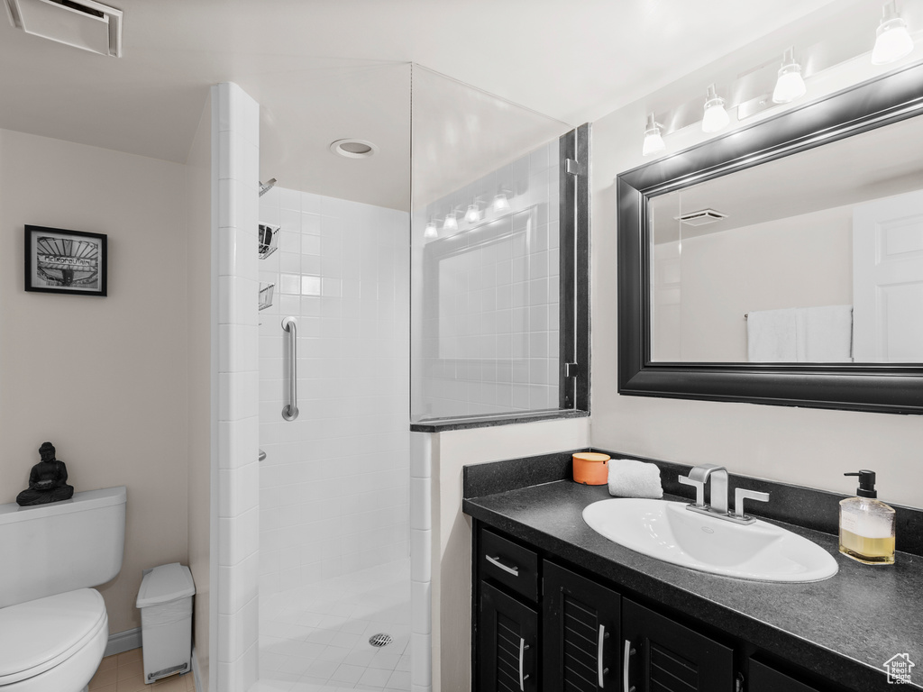 Full bath with vanity, toilet, a shower stall, and tile patterned floors