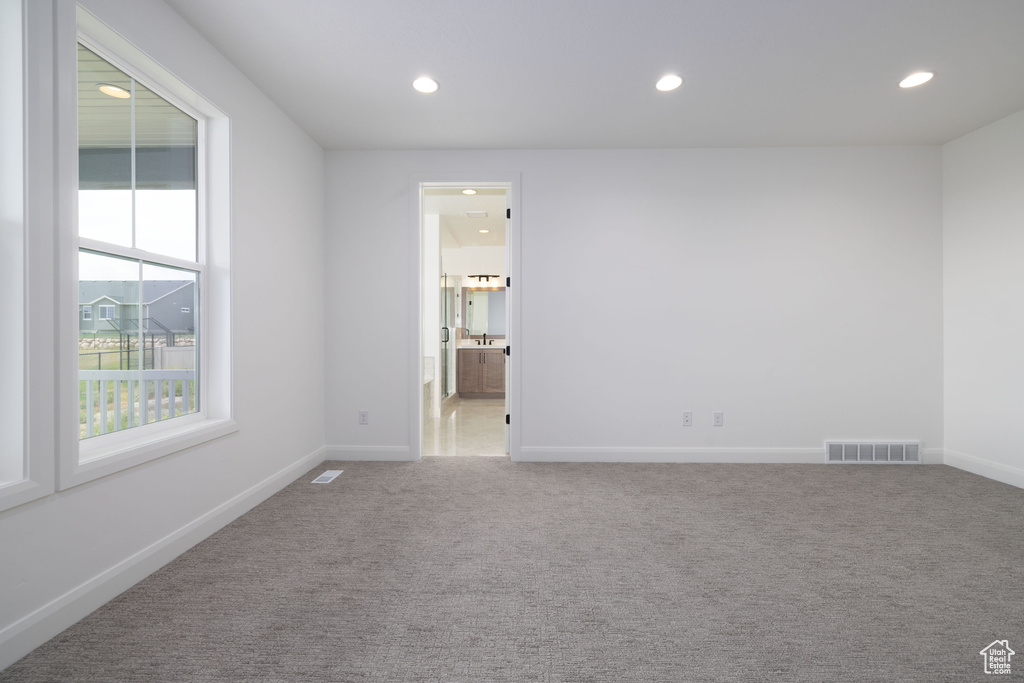 Carpeted empty room featuring recessed lighting and baseboards