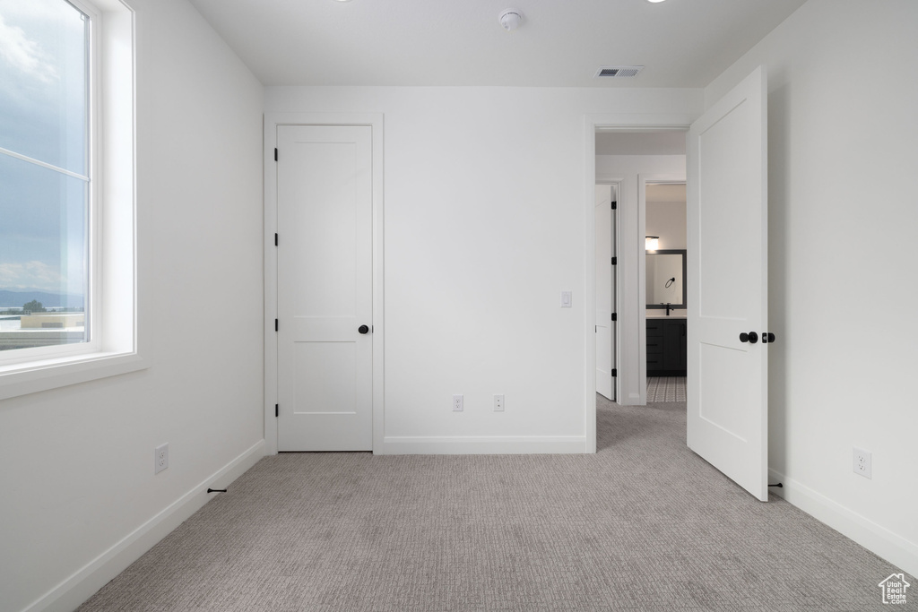 Unfurnished bedroom with carpet flooring and baseboards