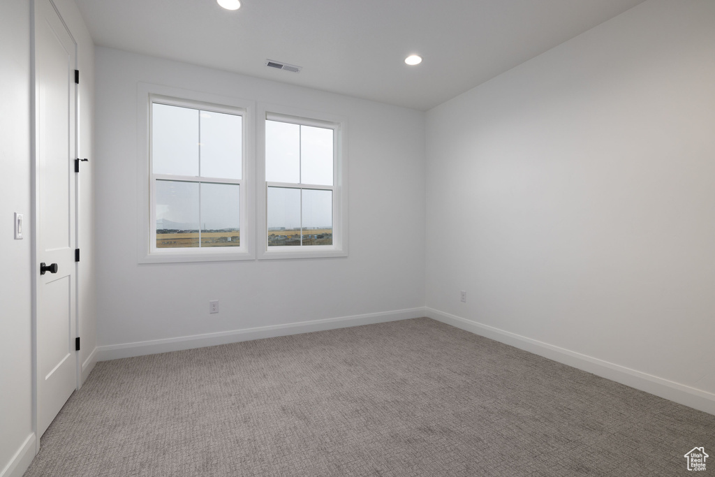 Unfurnished room featuring baseboards, light colored carpet, and recessed lighting