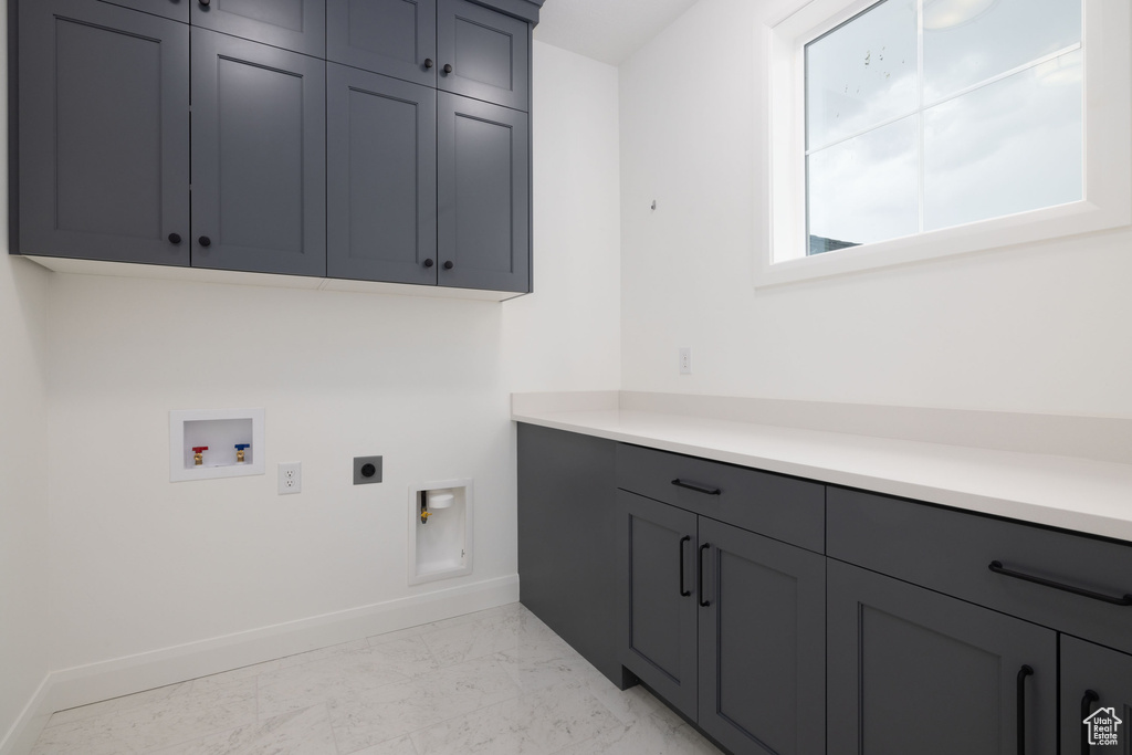 Laundry room with cabinet space, electric dryer hookup, washer hookup, baseboards, and light marble finish floors