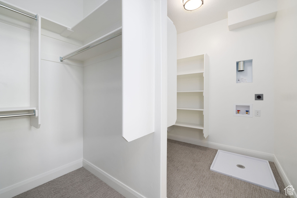 Laundry area with hookup for an electric dryer, carpet flooring, hookup for a washing machine, and baseboards