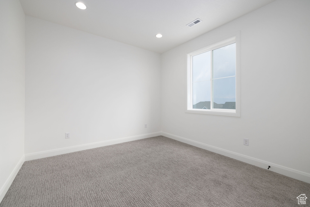 Carpeted empty room featuring baseboards and recessed lighting
