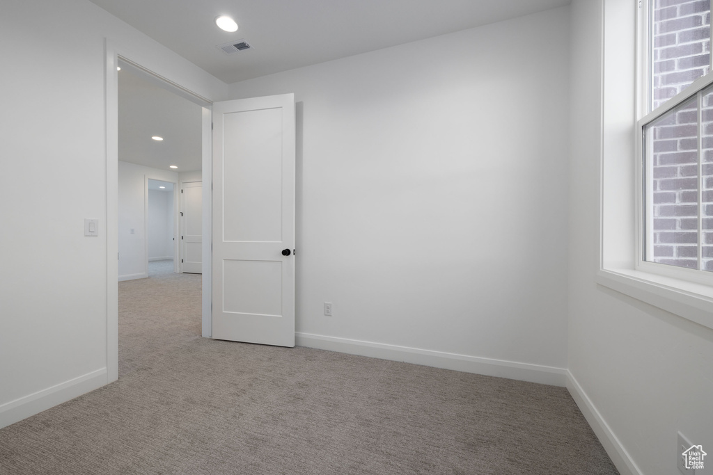 Unfurnished room featuring light carpet, baseboards, and recessed lighting
