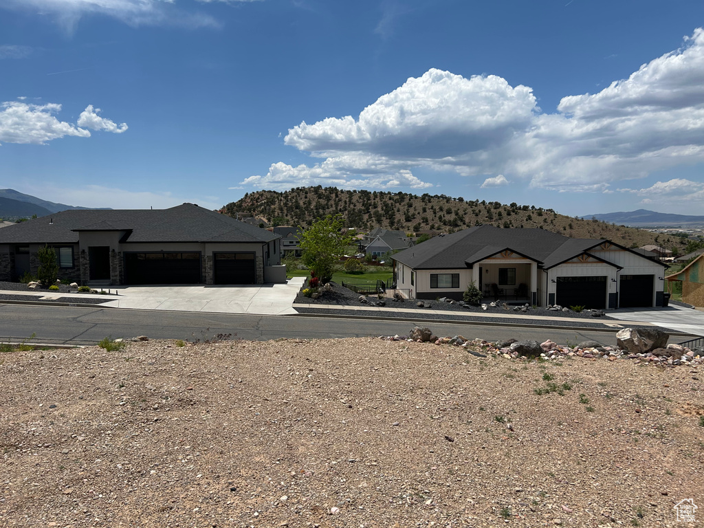 View of front of house with a residential view, a mountain view, and an attached garage