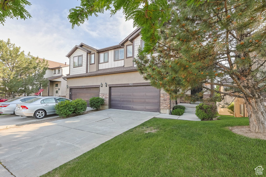 View of front of property with an attached garage, stucco siding, concrete driveway, and stone siding
