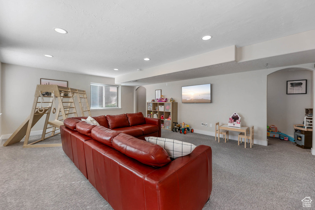 Living area with arched walkways, carpet flooring, recessed lighting, and baseboards