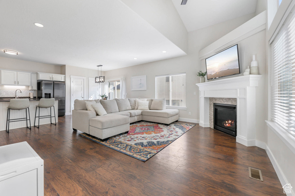 Living room featuring a glass covered fireplace, plenty of natural light, dark wood finished floors, and recessed lighting