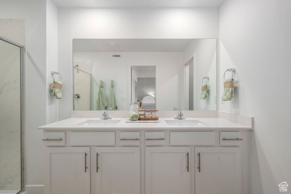 Bathroom featuring a stall shower and double vanity