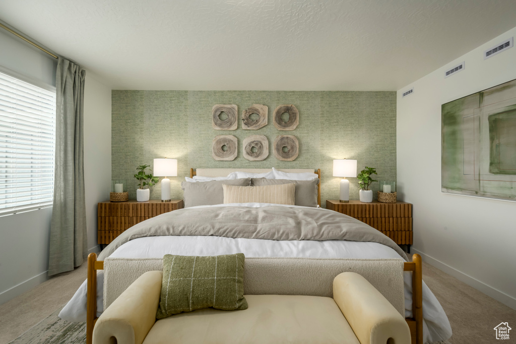 Carpeted bedroom featuring an accent wall, baseboards, multiple windows, and wallpapered walls