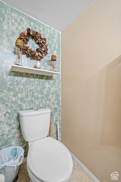 Bathroom with toilet, tile patterned flooring, and baseboards