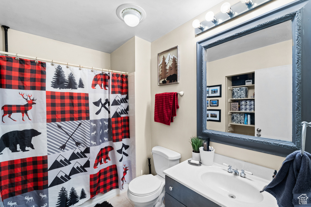 Bathroom with toilet, vanity, and a shower with curtain