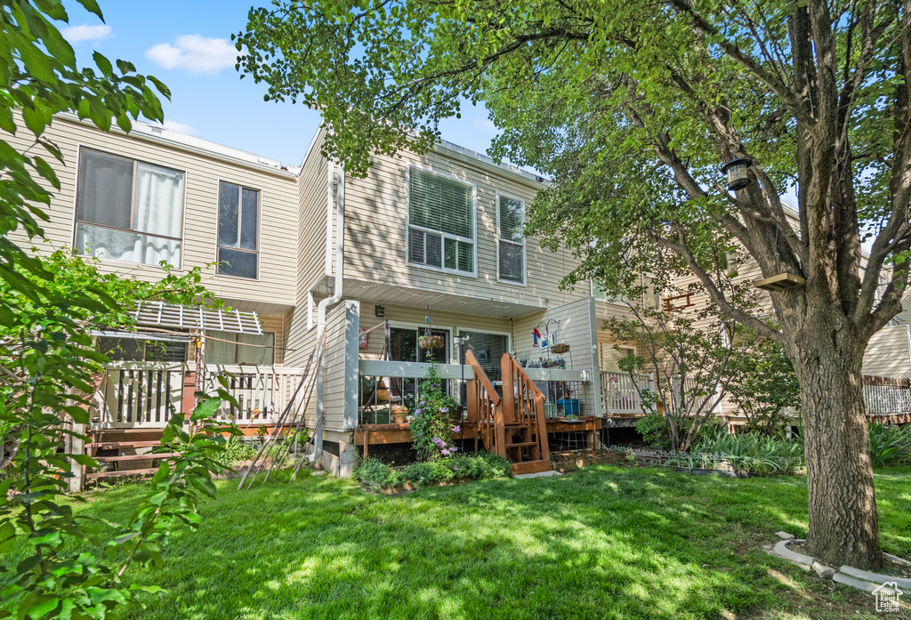 Rear view of property featuring a lawn and a wooden deck