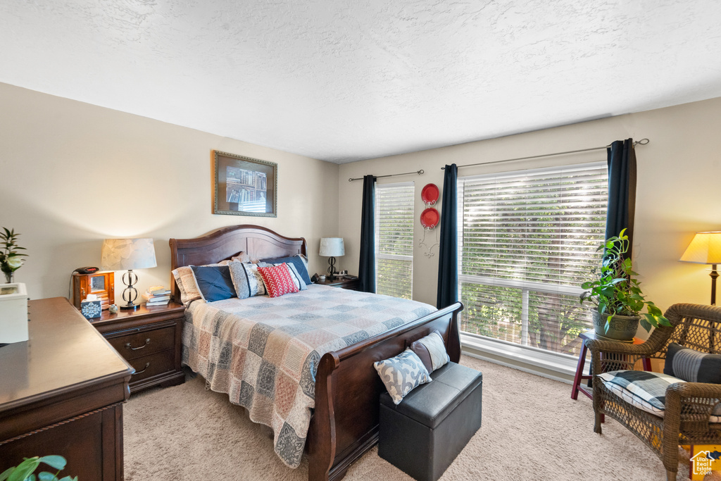 Bedroom featuring light carpet and a textured ceiling