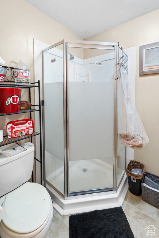 Full bathroom with tile patterned floors, toilet, and a shower stall