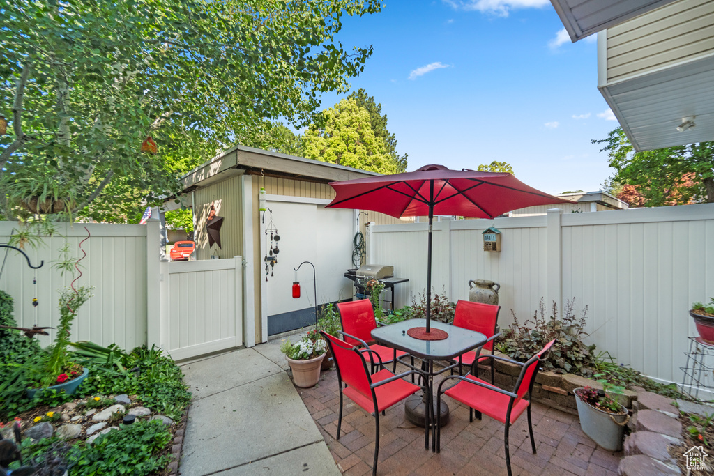 Fenced backyard featuring a patio, outdoor dining space, a gate, and grilling area