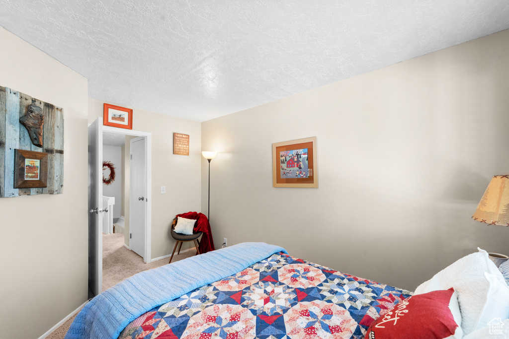 Bedroom with carpet floors, a textured ceiling, and baseboards