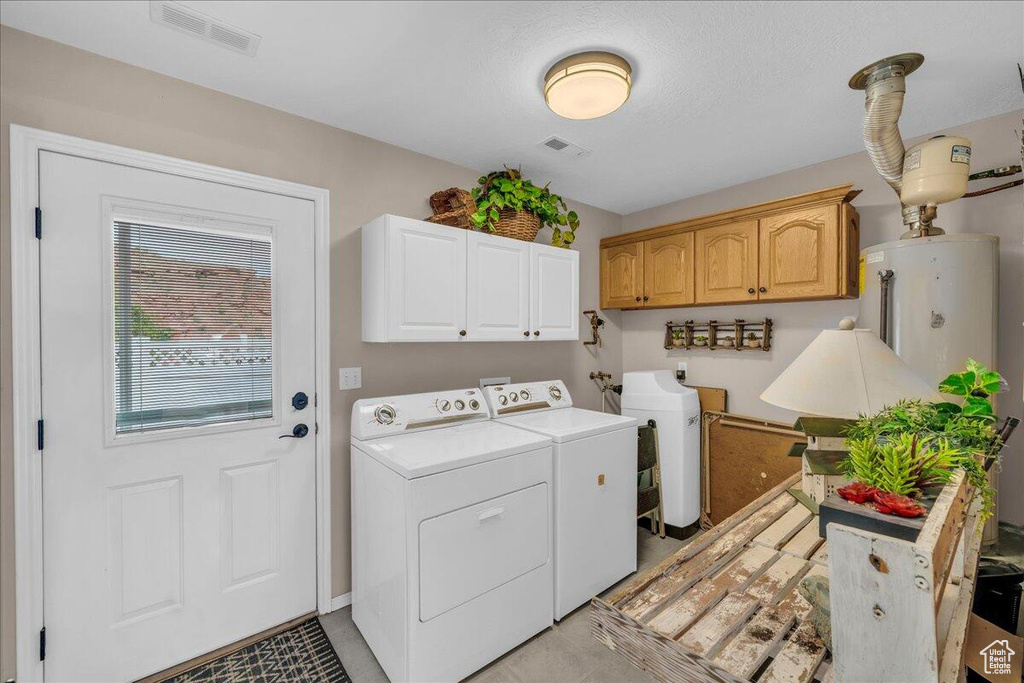 Laundry room with independent washer and dryer, cabinet space, and water heater