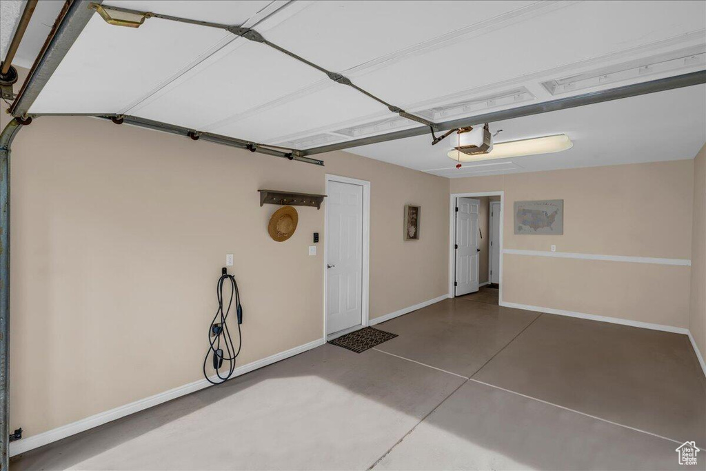Garage with a garage door opener and baseboards