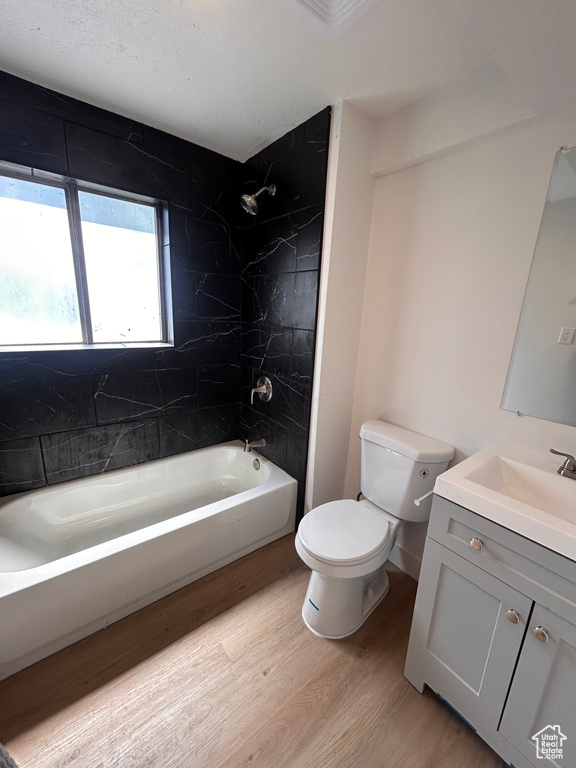 Full bath featuring toilet, wood finished floors, bathtub / shower combination, and vanity