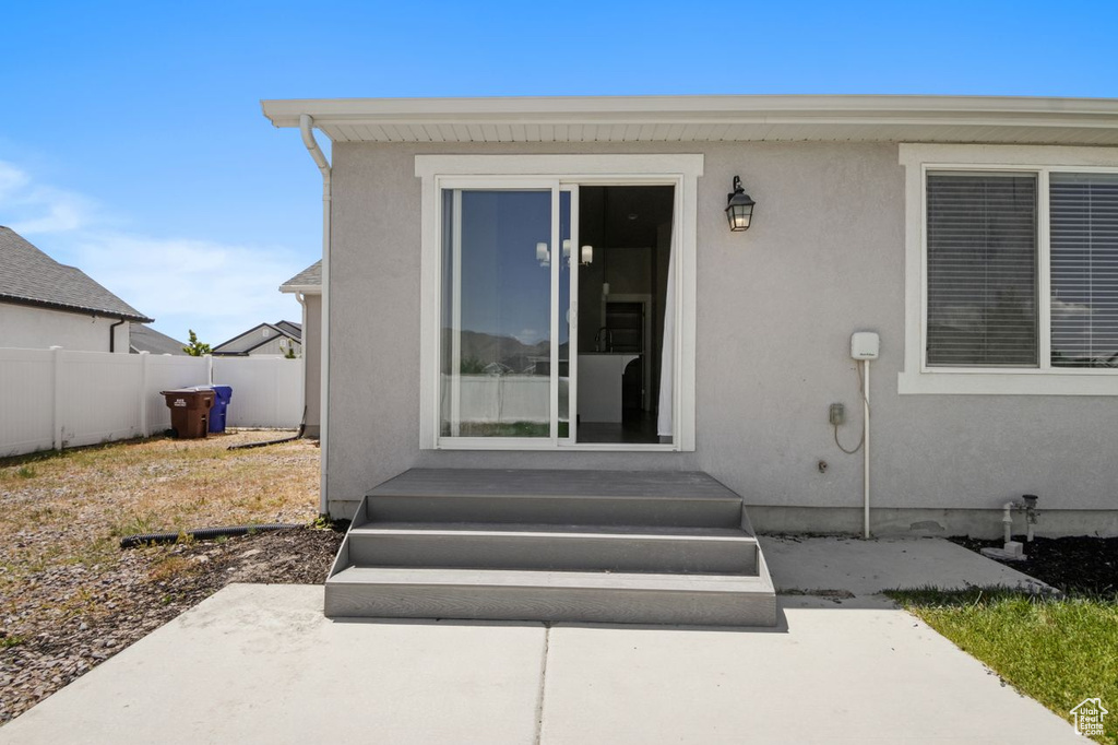 Entrance to property featuring stucco siding and a patio area