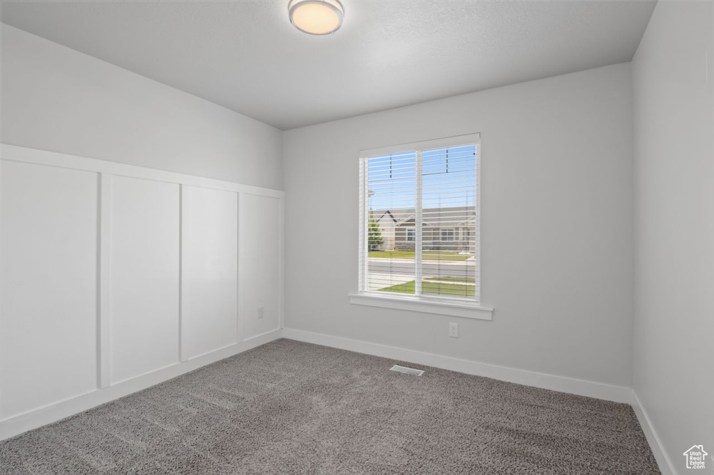 Carpeted spare room with baseboards