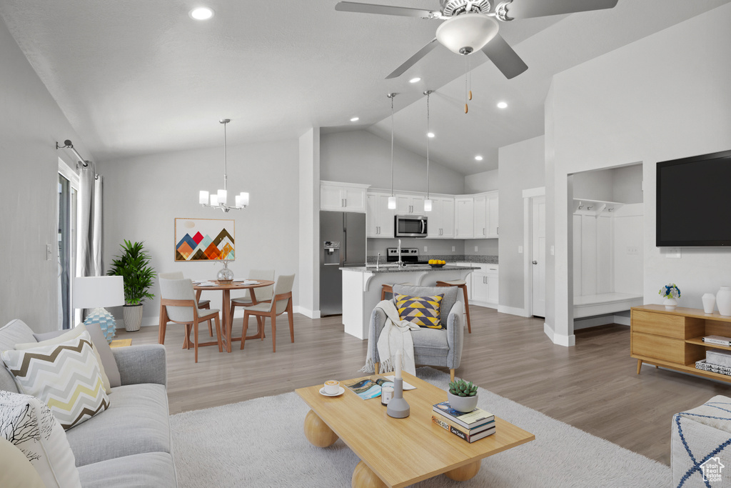 Living area featuring light wood-style floors, baseboards, a ceiling fan, recessed lighting, and high vaulted ceiling