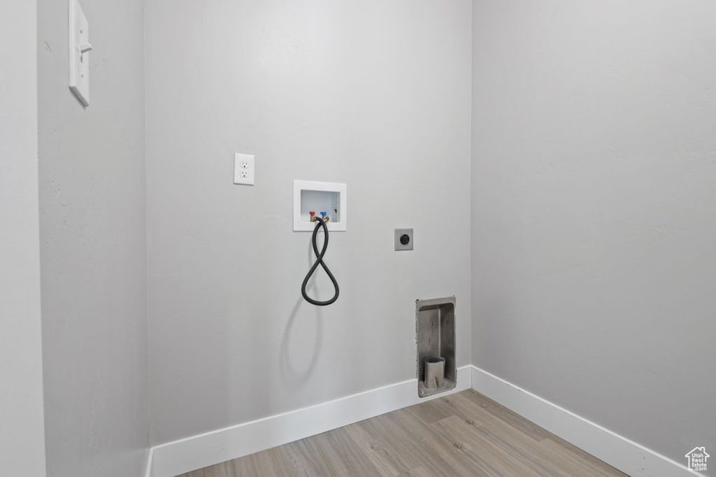 Laundry room featuring electric dryer hookup, light wood-type flooring, hookup for a washing machine, and baseboards