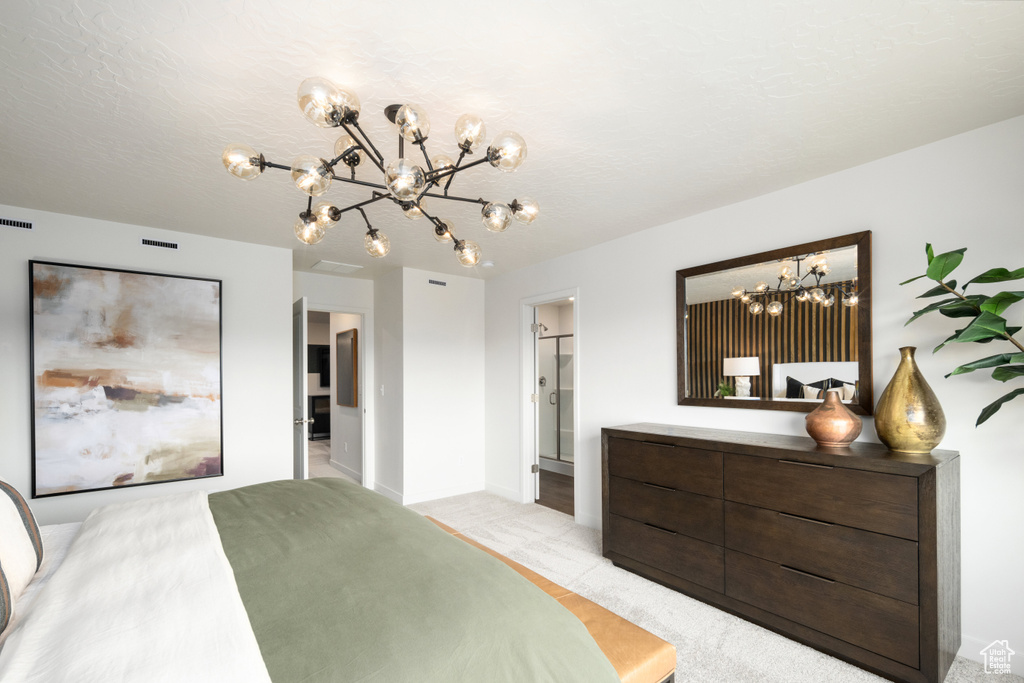 Bedroom featuring a chandelier, light carpet, and baseboards