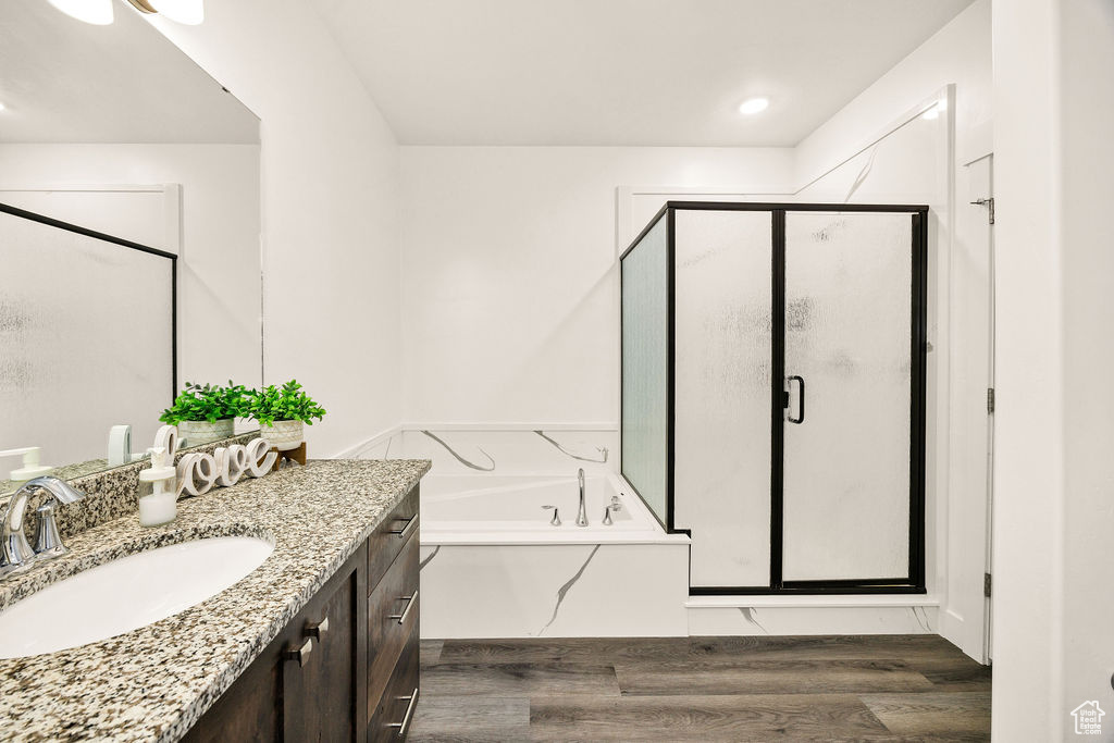 Bathroom with vanity, wood finished floors, a shower stall, and a garden tub