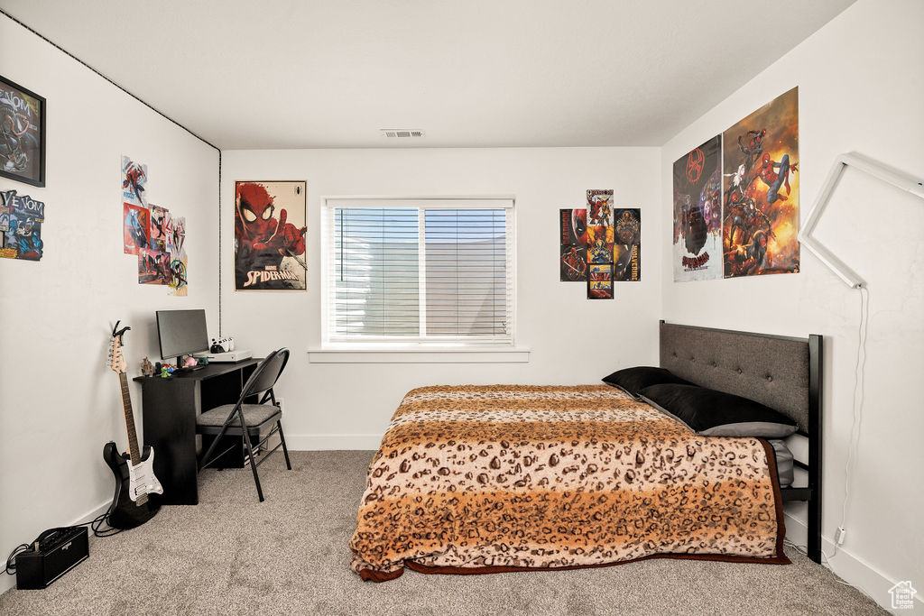 Carpeted bedroom featuring baseboards and an office area