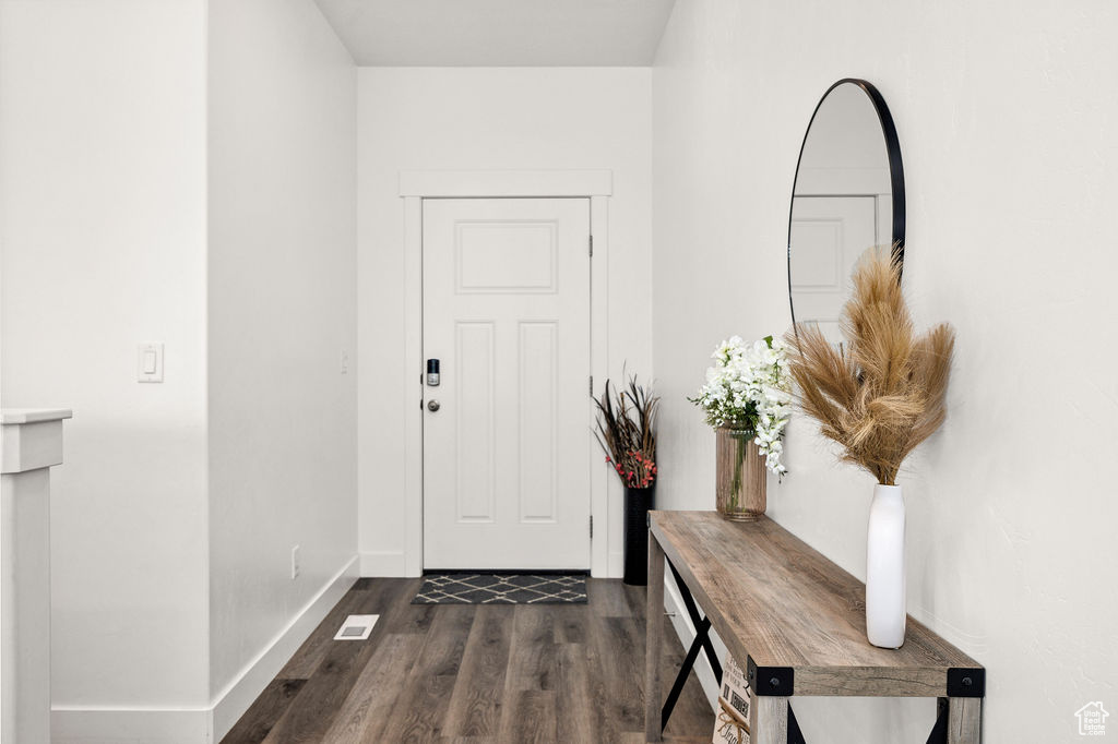 Entryway with dark wood-type flooring and baseboards