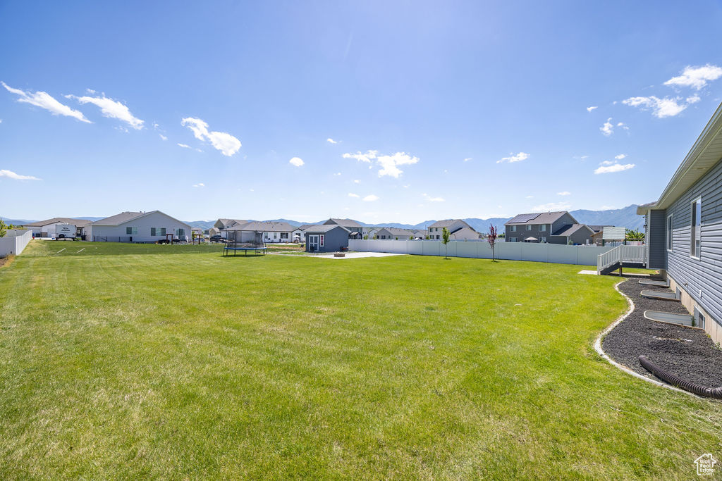 View of yard with a trampoline and a residential view