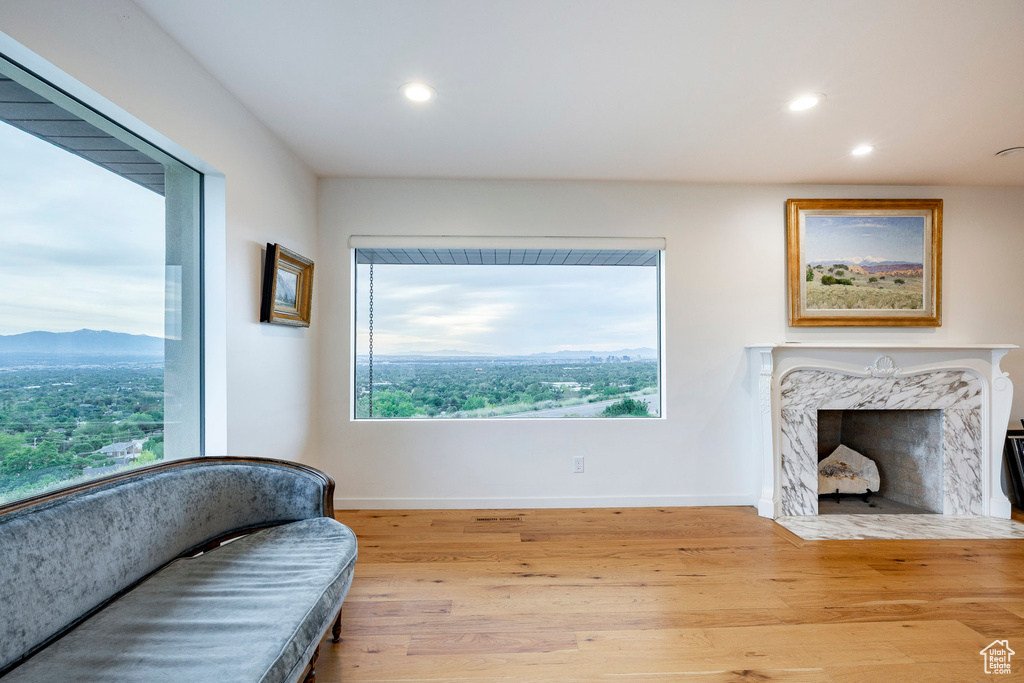 Living area with recessed lighting, wood finished floors, baseboards, a mountain view, and a fireplace