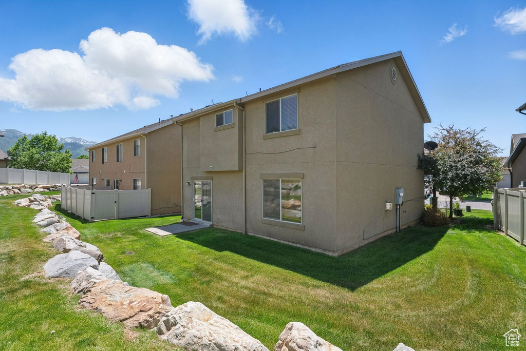 Rear view of house with stucco siding and a mountain view