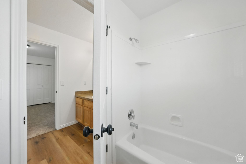 Full bath with wood finished floors, tub / shower combination, and vanity