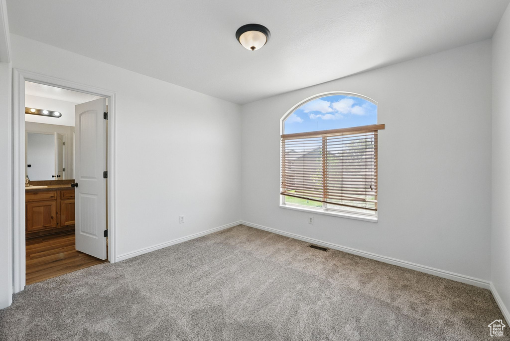 Spare room featuring carpet and baseboards
