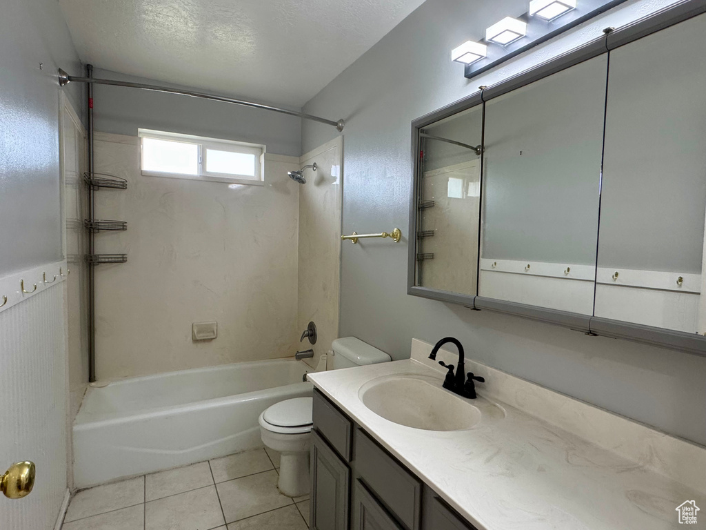 Bathroom featuring toilet, washtub / shower combination, vanity, and tile patterned flooring