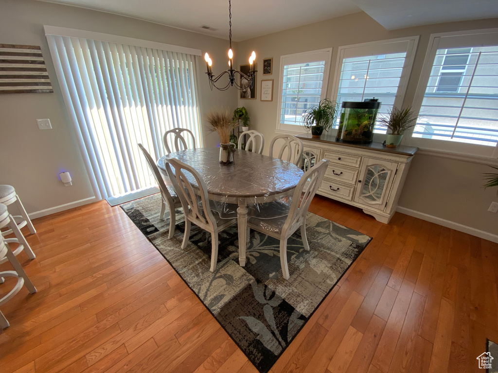 Dining room with a chandelier, baseboards, and light wood-type flooring