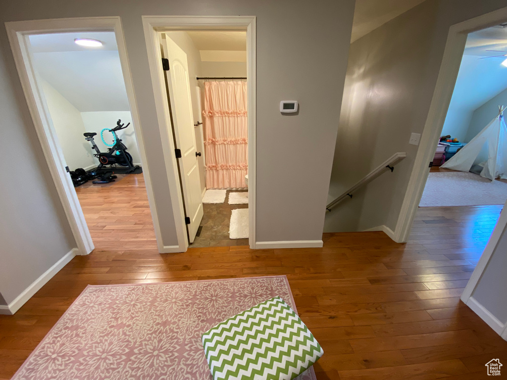 Corridor featuring an upstairs landing, hardwood / wood-style flooring, and baseboards