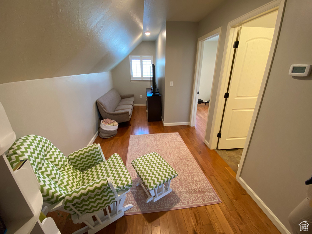 Bedroom with light wood-style floors, vaulted ceiling, and baseboards