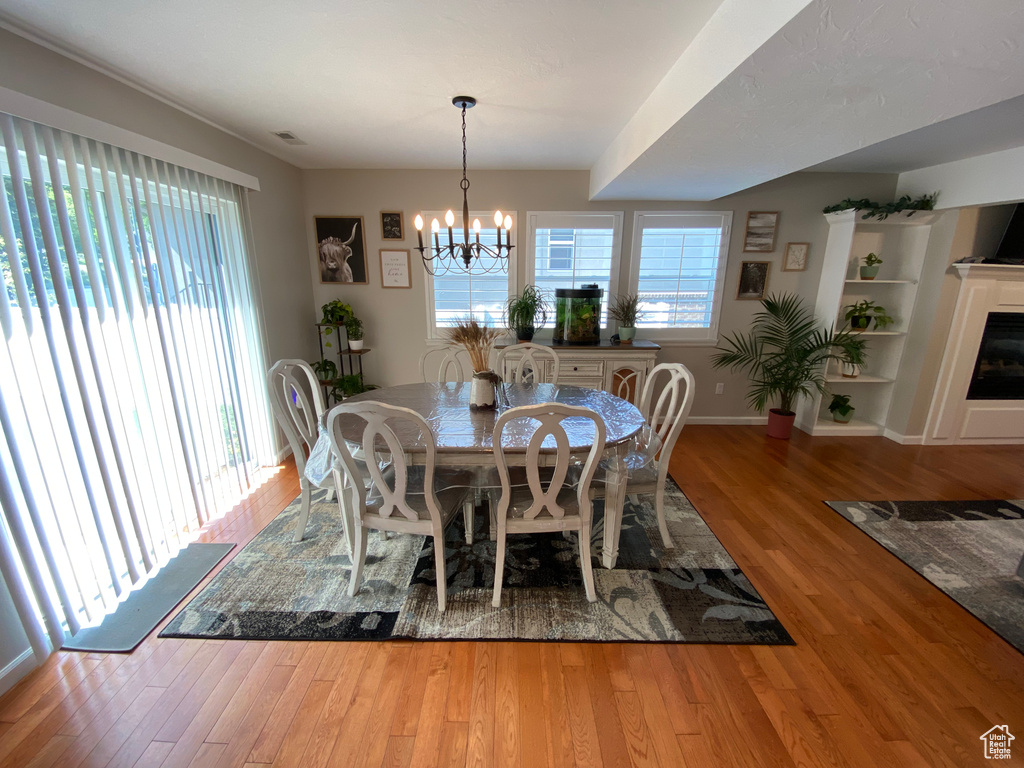 Dining area featuring a chandelier, wood finished floors, and baseboards