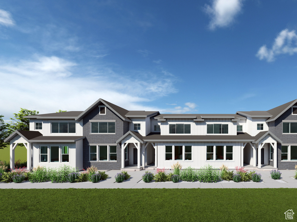 View of front of house featuring a front lawn and board and batten siding
