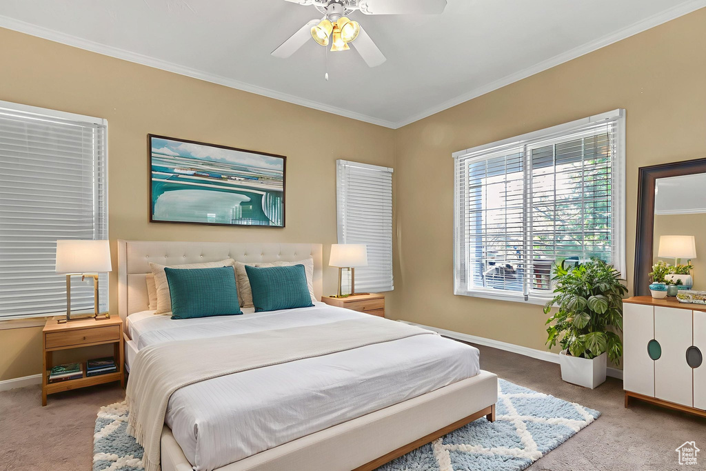 Carpeted bedroom featuring ornamental molding, baseboards, and ceiling fan