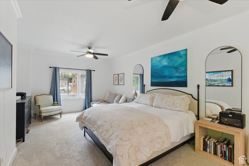 Carpeted bedroom featuring crown molding and ceiling fan