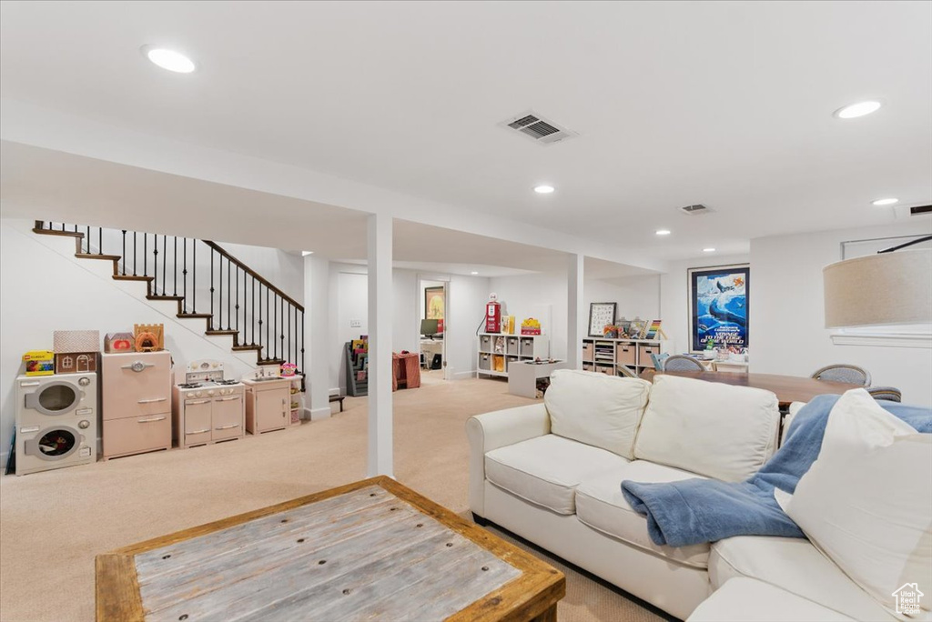 Living area with light colored carpet, recessed lighting, and stairway